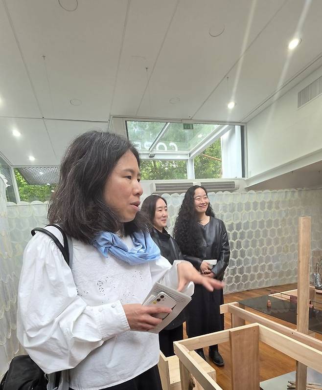 [베니스=뉴시스] 사진=박현주 미술전문기자 = 최빛나 예술감독과 최고은·노혜리 작가가 6일(현지시간) 이탈리아 베네치아 자르디니 한국관에서 제61회 베니스비엔날레 한국관 전시 ‘해방공간: 요새와 둥지’ 작품을 설명하고 있다. 뒤편으로 노혜리 작가의 오간자 설치작품 ‘베어링(Bearing)’이 펼쳐져 있다. 2026.05.06. hyun@newsis.com *재판매 및 DB 금지
