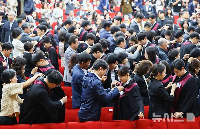 [과천=뉴시스] 황준선 기자 = 7일 오전 경기 과천시 정부과천청사 대강당에서 열린 신임 검사 임관식에서 가족들이 신임 검사에게 법복을 입혀주고 있다. 2026.05.07. hwang@newsis.com