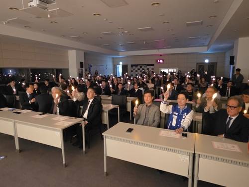 참석자들이 8일 창원시 마산회원구 양덕동 3.15아트홀 국제회의장에서 열린 마산YMCA 창립 80주년 기념식에서 모형 촛불을 들고 있다. /최석환 기자.