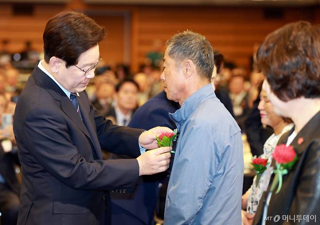 (서울=뉴스1) 허경 기자 = 이재명 대통령이 8일 서울 중구 대한상공회의소에서 열린 제54회 어버이날 기념식에서 순직 공무원 부모에게 카네이션을 달아주고 있다. 2026.5.8/뉴스1  Copyright (C) 뉴스1. All rights reserved. 무단 전재 및 재배포,  AI학습 이용 금지. /사진=(서울=뉴스1) 허경 기자