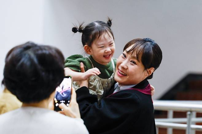 엄마는 검사 - 7일 경기 과천시 정부과천청사 법무부에서 열린 신임검사 임관식에서 한 신임검사가 딸을 안고 환하게 웃으며 기념사진을 찍고 있다. 올해 15회 변호사시험을 통과한 86명, 경력 법조인 48명 등 134명은 법무연수원에서 실무교육을 받은 뒤 일선 검찰청에 배치된다. 뉴스1