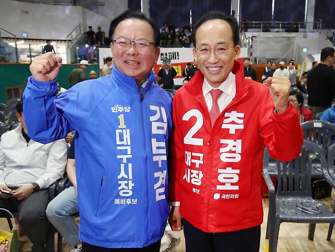 김부겸(왼쪽) 더불어민주당 대구시장 후보와 추경호 국민의힘 대구시장 후보가 1일 대구 북구 시민체육관에서 열린 한국노총 노동절 기념대회에서 만나 악수한 뒤 파이팅을 외치고 있다. 이들의 빅매치는 달구벌 대선(대구시장 선거)으로 불리며, 6·3 지방선거 최고의 관심사로 떠오르고 있다. 대구=뉴스1