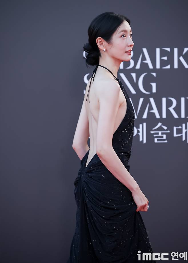 Park Ji-hyun revealed her beautiful figure in a single backless black dress.Actress Park Ji-hyun graced the red carpet of the 62nd Baeksang Arts Awards ceremony, held on the afternoon of the 8th at the outdoor plaza of COEX in Gangnam-gu, Seoul.In particular, Park Ji-hyun appeared wearing a black dress with a deeply exposed back, drawing all eyes to the event.i