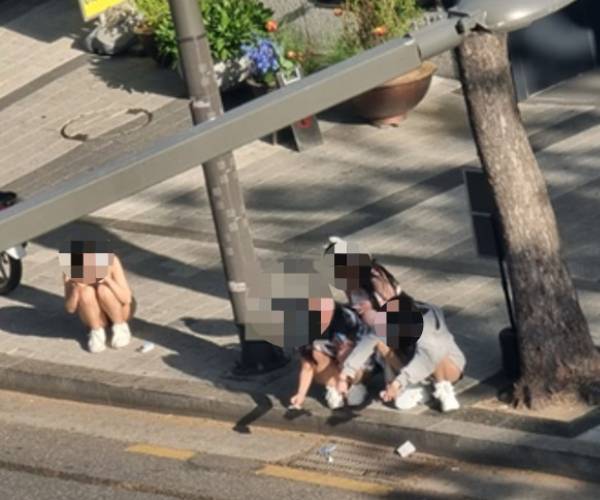 서울 강남구 청담동의 한 초등학교 인근 성인 방송 스튜디오 앞에서 출연자들이 선정적 의상을 입은 채 흡연을 하고 있다. [독자 제공]