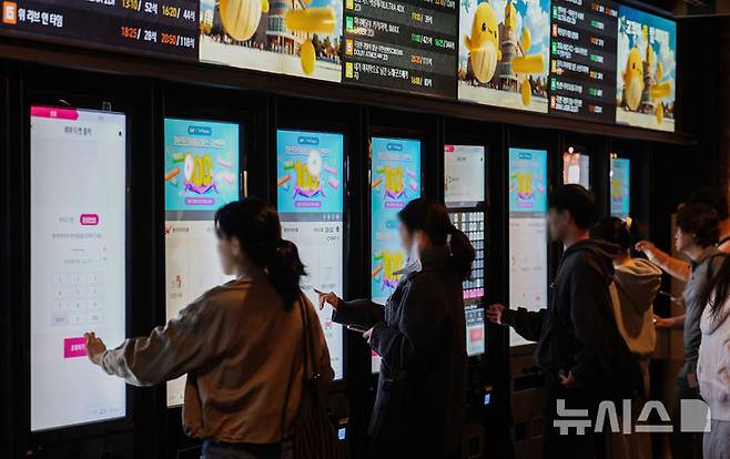 [서울=뉴시스] 권창회 기자 = 12일 서울 시내 영화관에서 시민들이 영화를 보기 위해 상영정보를 살펴보고 있다. 정부가 경기 침체가 예상되는 문화·관광·체육 분야 지원을 위해 약 4,600억원 규모의 예산을 추가로 투입한다. 그 중 전국 영화관 관람료 할인을 위한 예산으로 271억원을 편성해 1매당 6천원이 할인되는 티켓이 총 450만장 배포된다. 2026.04.12. kch0523@newsis.com