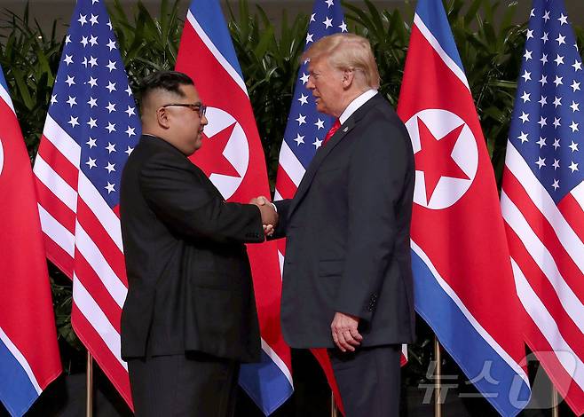 도널드 트럼프 미국 대통령이 첫 임기 때인 2018년 6월 12일(현지시간) 싱가포르 센토사 섬의 카펠라 호텔에서 김정은 북한 노동당 총비서와 합의문을 발표한 후 악수하고 있다. ⓒ 로이터=뉴스1