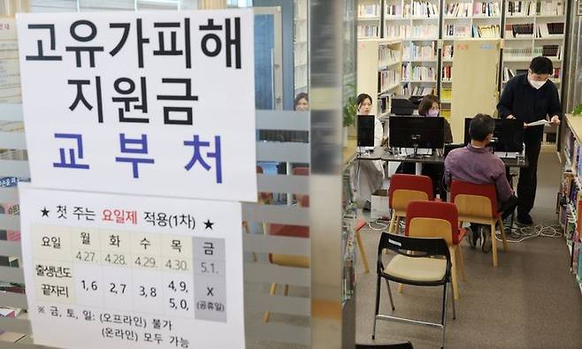 고유가 피해지원금 1차 지급 첫날인 지난달 27일 부산 부산진구 가야2동 주민센터에서 주민들이 지원금을 신청하고 있다. 연합뉴스