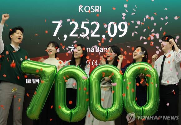 코스피가 사상 처음으로 종가 기준 7,000선을 돌파하며 장을 마친 6일 오후 서울 중구 하나은행 딜링룸에서 딜러들이 축하 세리머니를 하고 있다. 이날 코스피는 전장보다 447.57p(6.45%) 오른 7,384.56으로 마감하며 종가 기준 역대 최고치를 경신했다. 2026.5.6 [사진=연합뉴스]