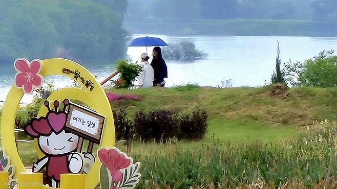 지난 3일 대구 달성군 사문진나루터에서 시민들이 가랑비가 내리는 잔잔한 낙동강을 바라보며 봄 정취를 느끼고 있다. /최상진기자