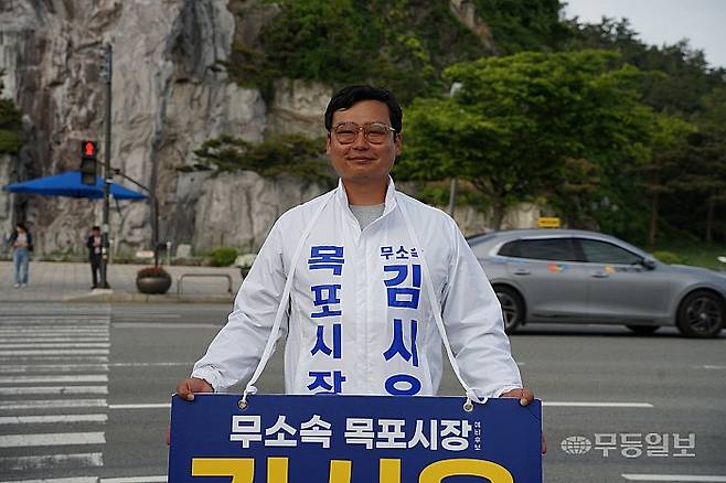 무소속 김시윤 목포시장 예비후보가 7일 오후 목포 25호광장 사거리에서 지나가는 차량들을 향해 인사하고 있다.