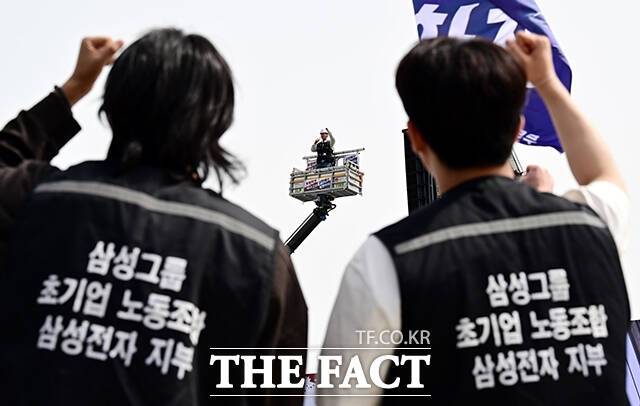 지난달 23일 삼성전자 평택캠퍼스 앞에서 열린 '4.23 투쟁 결의대회'에 참석한 초기업노조 삼성전자 지부 조합원들이 크레인 위에서 발언하는 최승호 삼성전자 지부 위원장을 바라보고 있다. /평택=임영무 기자