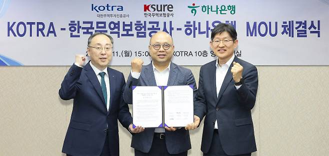 하나은행이 지난 11일 대한무역투자진흥공사(코트라), 한국무역보험공사와 함께 국내 수출기업의 안정적인 해외진출 및 수출확대 지원을 위한 업무협약을 체결했다. 코트라 본사에서 진행된 협약식에서 이정현 외환사업단 상무(왼쪽부터)가 강상엽 코트라 부사장, 장진욱 한국무역보험공사 부사장과 함께 협약서를 들고 기념 촬영을 하고 있다. 사진=하나은행 제공