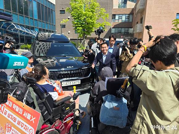 전국장애인차별철폐연대(전장연)가 12일 서울 마포구 공덕동 서울복지타운에서 일정을 마치고 이동하고 있는 오세훈 국민의힘 서울시장 후보의 차량을 막고 있다. [사진=김한빈 기자]