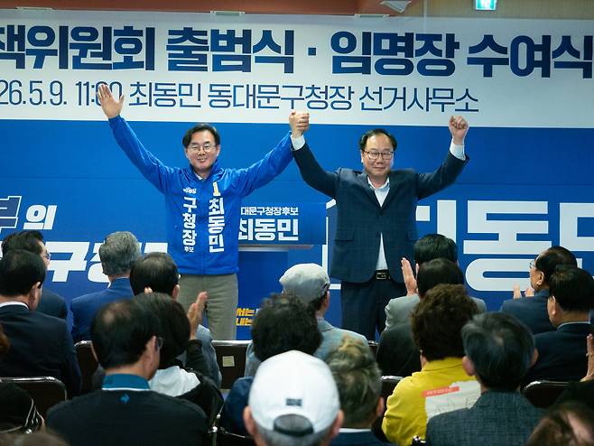 9일 오전 열린 최동민 더불어민주당 서울 동대문구청장 후보 선거대책위원회 출범식. 최 후보가 경선 상대이자 상임 선거대책위원장으로 합류한 김인호(오른쪽) 전 서울시의회 의장과 함께 환호에 답하고 있다. [최동민 후보 캠프 제공]
