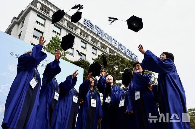 [서울=뉴시스] 김명년 기자 = 12일 오전 서울 용산구 숙명여자대학교 백주년기념관에서 열린 '졸업 50주년 홈커밍데이' 행사에서 학위복을 입은 50여년 전 졸업 동문들이 학사모를 던지며 기념촬영하고 있다. 2026.05.12. kmn@newsis.com
