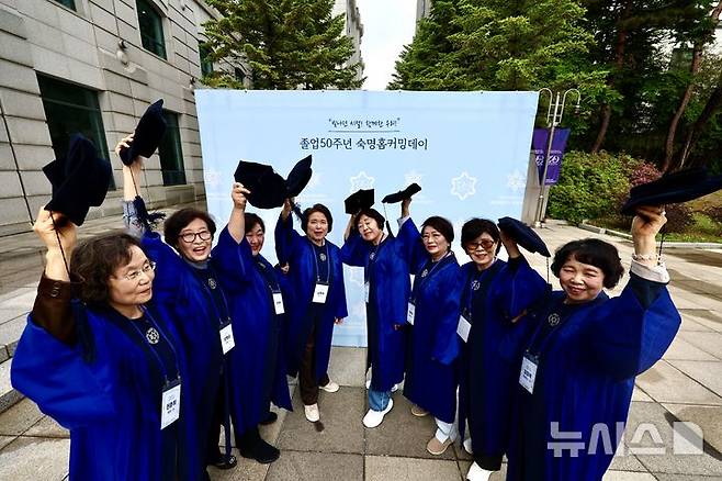 [서울=뉴시스] 김명년 기자 = 12일 오전 서울 용산구 숙명여자대학교 백주년기념관에서 열린 '졸업 50주년 홈커밍데이' 행사에서 학위복을 입은 50여년 전 졸업 동문들이 학사모를 흔들며 기념촬영하고 있다. 2026.05.12. kmn@newsis.com
