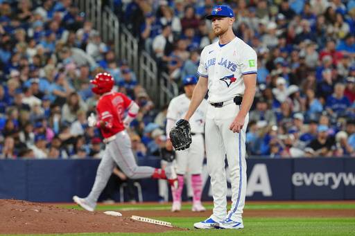 Toronto Blue Jays pitcher Eric Lauer, right, looks on as Los Angeles Angels' Oswald Peraza, back left, rounds the bases after hitting a two-run home run during the top of the fifth inning of a baseball game in Toronto, Sunday, May 10, 2026. (Frank Gunn/The Canadian Press via AP)