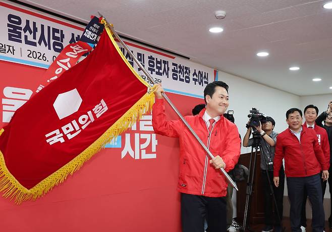 국민의힘 장동혁 대표가 11일 울산시 남구 울산시당에서 열린 '6·3 지방선거 울산선대위 발대식 및 공천장 수여식'에 참석해 당기를 흔들고 있다. /연합뉴스