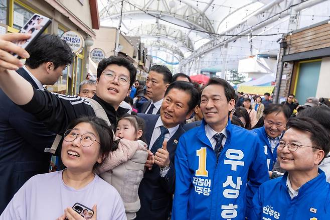 정청래 더불어민주당 대표와 우상호 강원지사 후보가 지난달 12일 춘천풍물시장을 방문, 시장 방문객과 기념 촬영을 하고 있다. 더불어민주당 제공