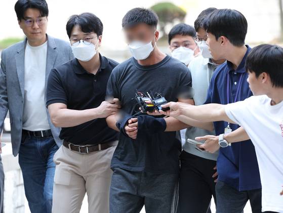 그룹 BTS 정국 등 국내 재력가들 자산을 탈취한 혐의를 받는 해킹조직 총책 중국 국적 전모씨가 지난해 8월 서울 서초구 서울중앙지법에서 열린 구속 전 피의자 심문(영장실질심사)에 출석하고 있다. 연합뉴스