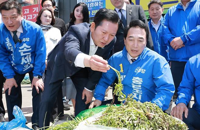 지난 1일 홍성전통시장을 찾은 정청래 대표와 박수현 충남지사 후보 뒤로 홍성군 광역·기초의원 후보들이 파란 점퍼를 뒤집어 입고 있다. 연합뉴스