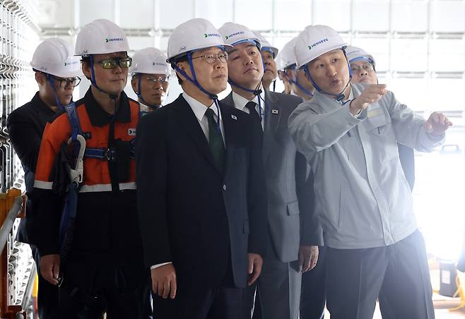 President Lee Jae Myung, center, looks at a liquefied natural gas carrier at Korean shipbuilding company HD Hyundai Heavy Industries in Ulsan on May 13. [JOINT PRESS CORPS]
