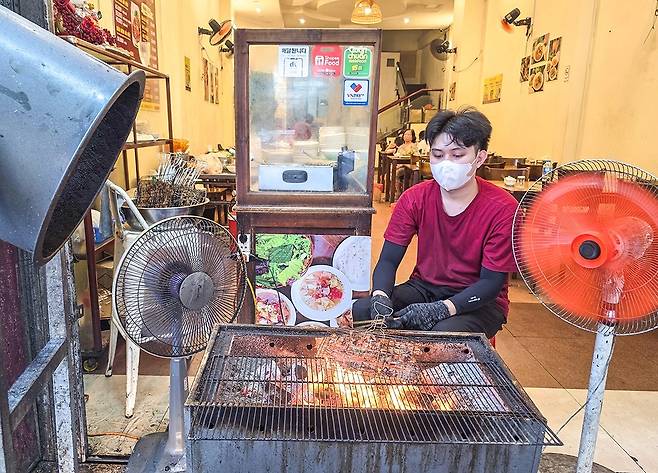 분짜 식당에서 고기를 굽는 종업원[사진/이동경 기자]