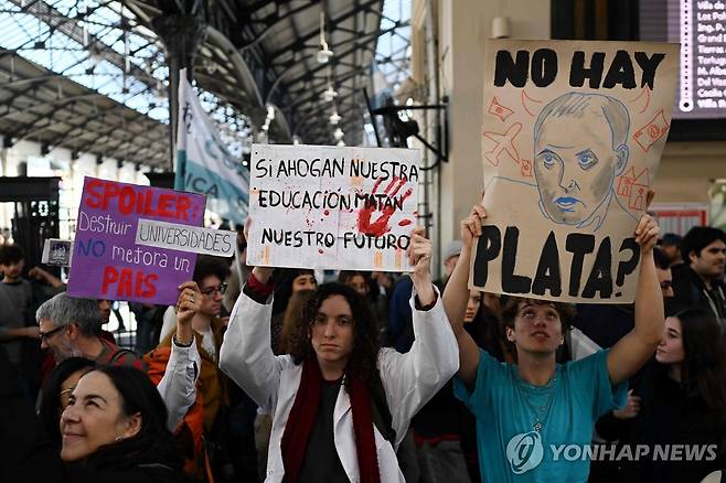 아르헨티나 국립대학 지지 대규모 시위 (부에노스아이레스= AFP 연합뉴스) 12일(현지시간) 주최 측 추산 150만명이 아르헨티나 전역에서 국립대 지지 대규모 시위에 참여했다. 하비에르 밀레이 대통령 취임 이후 4번째 국립대 지지 시위로 시위대는 정부를 향해 대학재정지원법을 즉각 시행하고 대학 예산 및 교수 임금을 복원하라고 요구했다. 한 시위자가 "교육을 질식시키는 것은 우리 미래를 죽이는 것이다"라는 팻말을 들고 있다. photo@yna.co.kr 2026.5.13