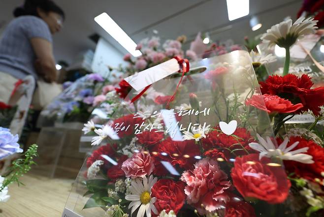 스승의 날을 하루 앞둔 14일 서울 서초구 양재꽃시장에서 한 시민이 카네이션 꽃바구니를 살펴보고 있다. /뉴시스