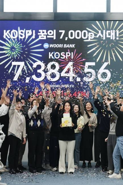 코스피가 사상 처음으로 종가 기준 7000선을 돌파하며 장을 마친 5월 6일 오후 서울 중구 우리은행 본점 딜링룸에서 직원들이 케이크를 들고 축하 세리머니를 하고 있다. 사진=연합뉴스
