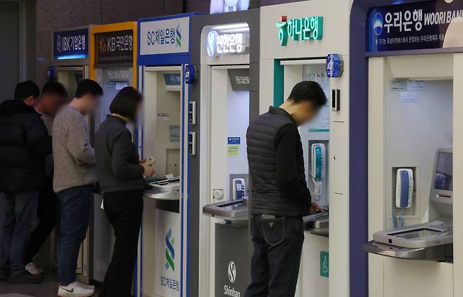 서울 시내의 한 건물에서 시민들이 은행 현금자동입출금기(ATM)를 이용하고 있다.     [뉴시스]