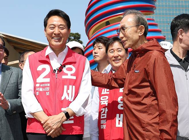 오세훈 국민의힘 서울시장 후보가 15일 서울 청계광장에서 이명박 전 대통령을 만나 대화를 나누고 있다. 뉴스1