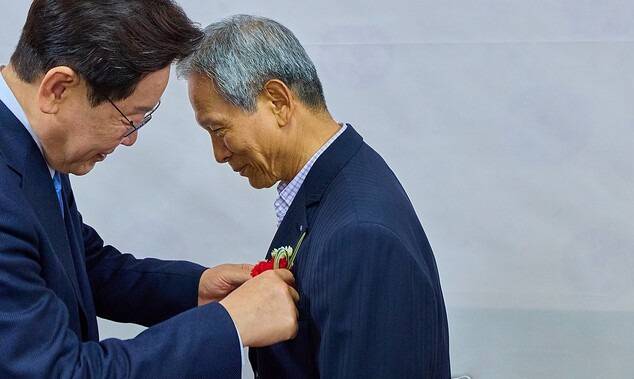 이재명 대통령이 경북 안동 한 식당에서 삼계초등학교 은사 박병기 선생님에게 카네이션을 달아드리고 있다. 연합뉴스