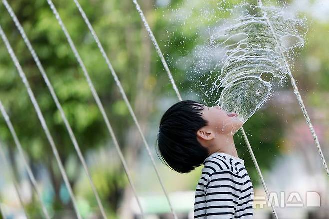 [서울=뉴시스] 김명년 기자 = 초여름 날씨를 보인 지난 14일 오후 서울 종로구 광화문광장 분수대 터널에서 한 아이가 물놀이를 하며 더위를 식히고 있다. 2026.05.14. kmn@newsis.com