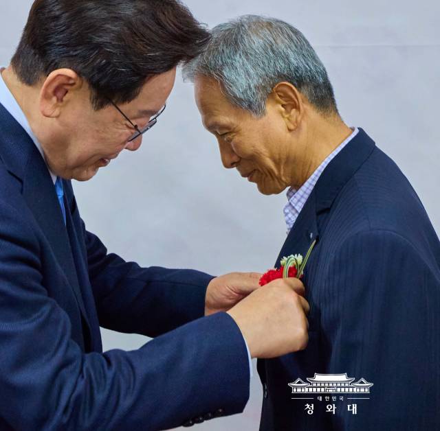이재명 대통령이 스승의날인 15일 안동의 한 식당에서 초등학교 은사인 박병기 선생님을 만나 가슴에 카네이션을 달아 드리고 있다. 청와대 제공
