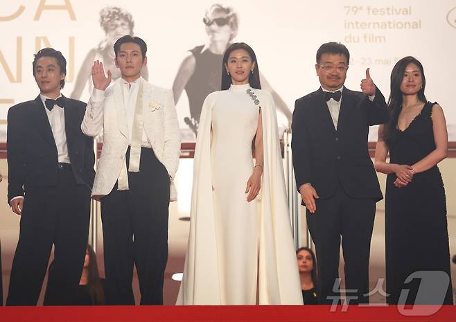 16일(현지시간) 프랑스 남부 소도시 칸 팔레 데 페스티발(Palais des Festivals) 뤼미에르 대극장에서 열린 제79회 칸 국제영화제 미드나잇 스크리닝 초청작 ‘군체’ 공식 시사회에서 연상호 감독과 주연배우 전지현, 지창욱, 구교환 등 출연진이 레드카펫에 올라 손 인사를 하고 있다. 2026.5.16 ⓒ 뉴스1 이준성 특파원