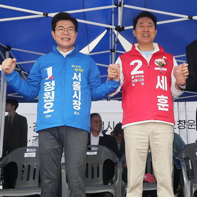 정원오 더불어민주당 서울시장 후보(왼쪽)와 오세훈 국민의힘 서울시장 후보가 3일 오전 서울 용산구 효창운동장에서 열린 제44회 서울특별시장기 축구대회 개회식에 참석해 손을 맞잡은 채 포즈를 취하고 있다. 2026.5.3/뉴스1