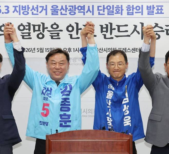 지난 15일 울산시의회 프레스센터에서 더불어민주당 울산시당과 진보당 울산시당이 6·3 지방선거 울산시장 후보 단일화 합의를 발표한 후 김종훈 진보당 후보, 김상욱 민주당 후보가 손을 잡고 인사하고 있다. 연합뉴스