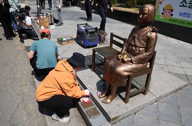 6일 서울 종로구 옛 주한 일본대사관 앞 평화의 소녀상에서 제작자와 관계자들이 보수 작업을 하고 있다. 소녀상을 둘러싼 경찰 바리케이드는 이날 6년만에 철거됐다./사진=뉴스1.