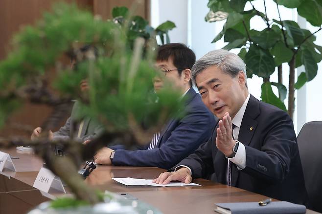 신현송 한국은행 총재가 14일 서울 중구 한국은행에서 박홍근 기획예산처 장관과 회동하며 선물받은 소나무 분재를 바라보고 있다.  권욱 기자