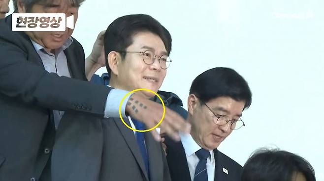 정원오(왼쪽에서 두 번째) 더불어민주당 서울시장 후보 뒤에서 김진석(맨 왼쪽) 작가가 문신이 새겨진 손을 뻗고 있는 모습. 페이스북 캡처