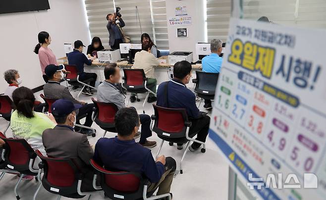 [부산=뉴시스] 하경민 기자 = 정부 고유가 피해지원금 2차 신청·지급 첫날인 18일 부산 부산진구 개금3동행정복지센터에서 주민들이 선불카드형 지원금을 받고 있다. 2026.05.18. yulnetphoto@newsis.com