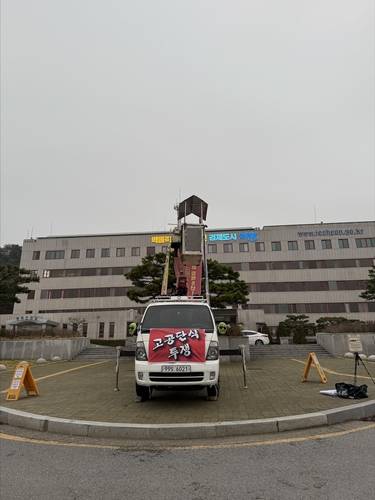 "A아동양육시설 학대 재조사하고 피해자들에게 보상하라"  고아권익연대가 제천시청 앞에서 고공 사다리차를 세워놓고 시위를 벌이는 모습
[고아권익연대 제공]