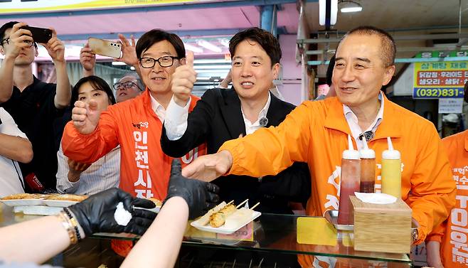 ▲ 이준석(가운데) 개혁신당 대표가 정승연 연수구갑 국회의원 보궐선거 후보, 이기붕 인천시장 후보와 19일 오후 인천 연수구 옥련시장을 찾아 상인과 인사하고 있다. /이재민 기자 leejm@incheonilbo.com