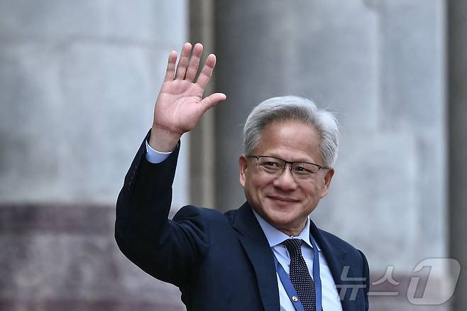 젠슨 황 엔비디아 최고경영자(CEO) 가 14일(현지 시간) 중국 베이징 인민대회당에서 열린 도널드 트럼프 미국 대통령 환영식 후 취재진을 향해 손을 흔들고 있다. ⓒ AFP=뉴스1
