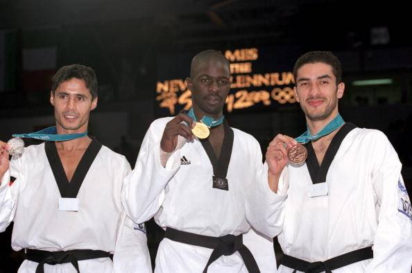 Victor Manuel Estrada Garibay of Mexico (far right) celebrates with his bronze medal alongside silver medalist Faissal Ebnoutalib of Germany (far left) and gold medalist Angel Matos of Cuba (center) after the men’s 80-kilogram Taekwondo competition at the 2000 Sydney Summer Olympics at the State Sports Centre in Sydney, Australia, on Sept. 29, 2000. (Billy Stickland/Getty Images)