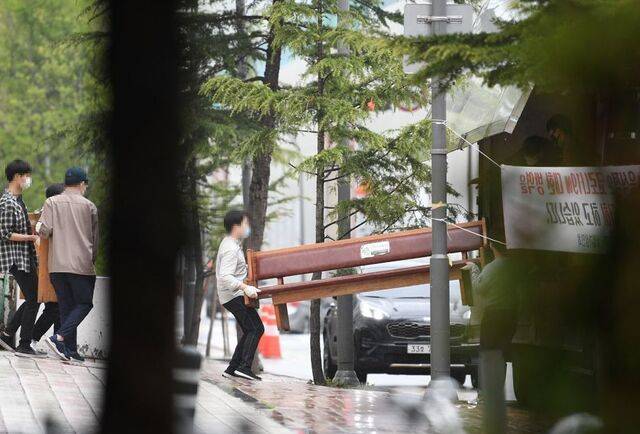 신천지 청년 신도들이 2020년 경기도 과천 신천지 총회 본부 건물 밖으로 장의자를 옮기고 있다. 국민일보DB