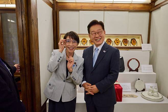이재명 대통령이 지난 19일 경북 안동 한 호텔에서 열린 다카이치 사나에 일본 총리와의 친교 일정에서 다카이치 총리가 선물한 안경을 쓰고 기념 촬영을 하고 있다. 왼쪽은 이재명 대통령의 안경을 쓴 다카이치 총리. [청와대 제공] [연합]