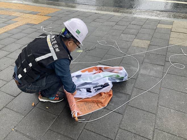 20일 서울시 불법 현수막 기동정비반 직원이 용산구 삼각지역 교차로에서 철거한 현수막을 정리하고 있다. 손인규 기자