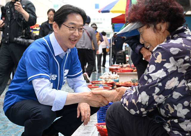더불어민주당 김경수 경남도지사 후보가 21일 오전 고성군 고성읍 고성시장에서 상인과 악수를 하고 있다./김승권 기자/